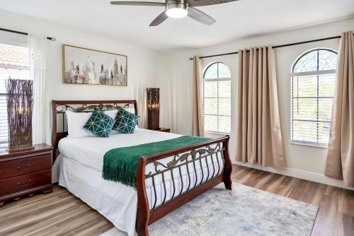 a bedroom with a bed and two windows at Spacious 4BR Home Perfect for Families in Orlando