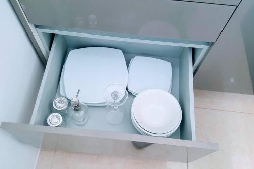two white toilets sitting in a glass cabinet at 2-Bedroom Condo with City Skyline View in Vientiane