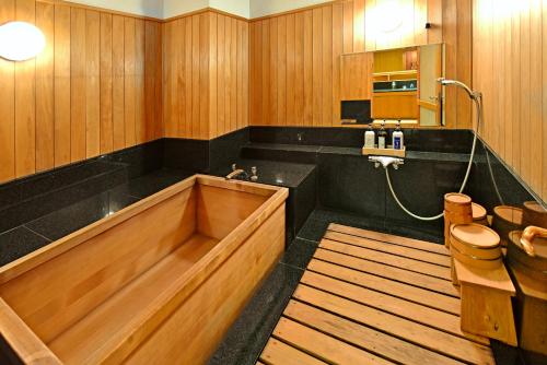 La salle de bains est pourvue d'une baignoire en bois et de toilettes. dans l'établissement THE GLOBAL VIEW Nagasaki, à Nagasaki