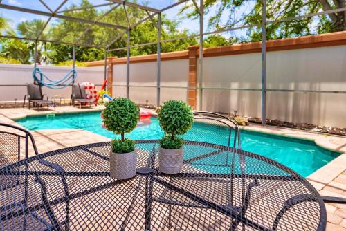 a table with plants on it next to a pool at Spacious 4BR Home Perfect for Families in Orlando