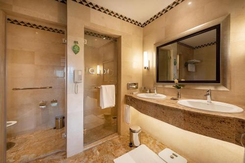 een badkamer met 2 wastafels en een douche bij Nairobi Serena Hotel in Nairobi