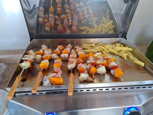 a grill with skewers of food and french fries at La Maison du Moulin de Tartay in Avignon