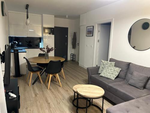 a living room with a couch and a table at Apartament Sosnowa 4 in Mielno