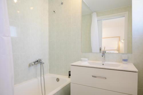 uma casa de banho com um lavatório, um chuveiro e uma banheira em Summer Retreat Sea View 4th floor em Agios Nikolaos