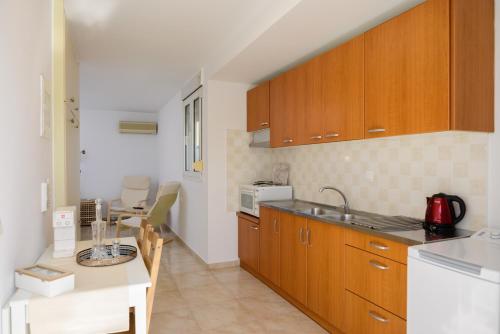 a kitchen with wooden cabinets and a counter top at Summer Retreat Sea View 4th floor in Agios Nikolaos