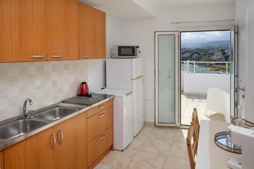 uma cozinha com um lavatório e um fogão forno superior em Summer Retreat Sea View 4th floor em Agios Nikolaos