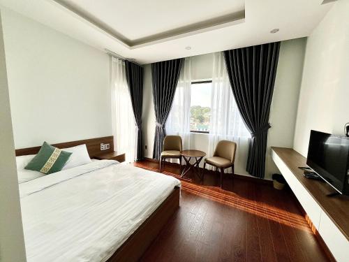 a hotel room with a bed and a television at SAFFRON Dalat in Da Lat