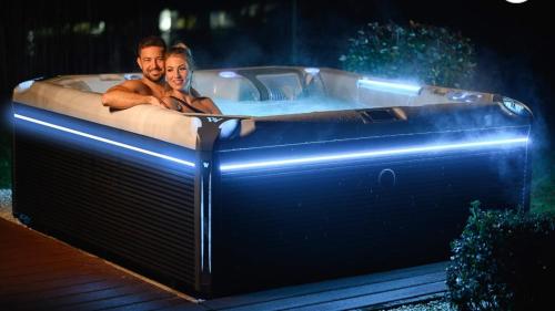 a man and a woman laying in a hot tub at The White Home Broadway Love Room in Châteauroux