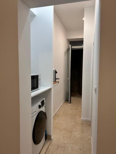 une petite cuisine avec une cuisinière et un micro-ondes dans l'établissement Appartement T1 intra-muros, à Avignon