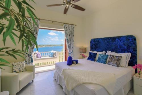 1 dormitorio con 1 cama y balcón con vistas al océano en Stunning 3 bedroom villa with Pool & Jacuzzi, en Gaynors