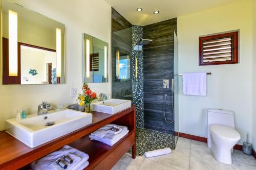 y baño con 2 lavabos y ducha. en Stunning 3 bedroom villa with Pool & Jacuzzi, en Gaynors