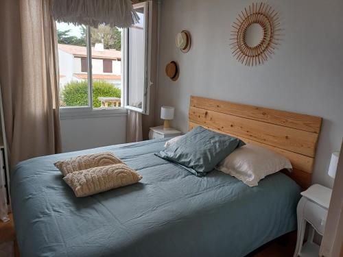 - un lit avec 2 oreillers et un miroir mural dans l'établissement Mon coin de Paradis, à Saint-Jean-de-Monts