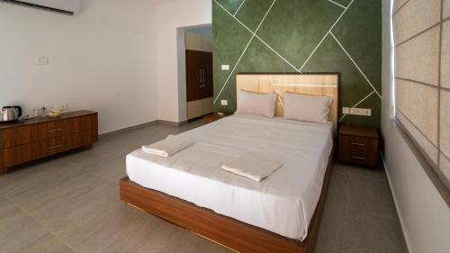 a bedroom with a large bed with white sheets at Jungle Drive Resort Vayalada in Kozhikode