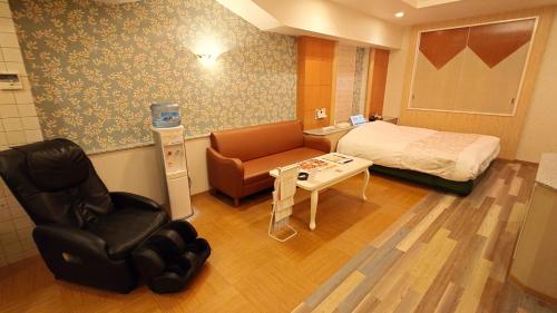 Habitación hospitalaria con cama y silla en ホテルシエル富士店 -大人専用-, en Fuji