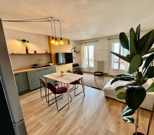 un salon avec une table et une cuisine dans l'établissement Appartement rénové avec balcon à La Joliette, à Marseille