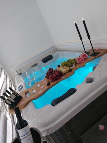 a jacuzzi tub with a table filled with grapes at George's point of view in Naousa