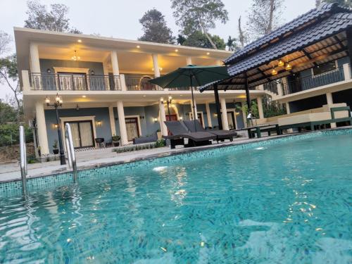une grande piscine en face d'une maison dans l'établissement Villa Forever Coorg, à Madikeri