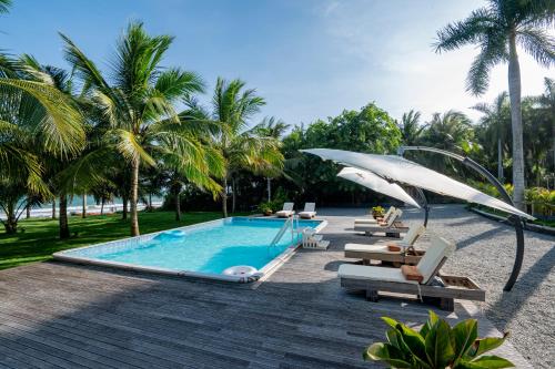 a swimming pool with lounge chairs and an umbrella at Anyu Hotel Sanya in Sanya