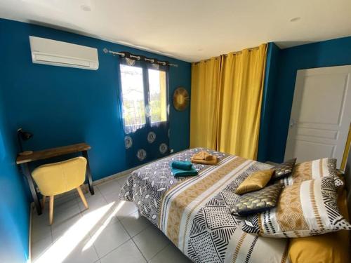 um quarto azul com uma cama e uma secretária em Gite Combe Ferrade en pleine nature em Campagnac-lès-Quercy