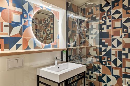 bagno con lavandino e specchio di Campanile Villennes-Sur-Seine - Poissy - Hôtel rénové en 2024 a Villennes-sur-Seine