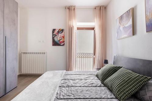 a bedroom with a bed and a window at Dimora del Sole - Civico 13 in LʼAquila