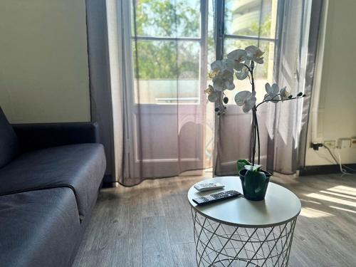un soggiorno con divano e tavolo con una pianta di BWR - Bellssimo bilocale vicino ai navigli a Milano