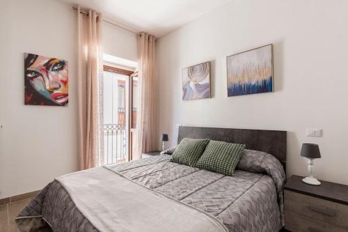 a bedroom with a bed and paintings on the wall at Dimora del Sole - Civico 13 in LʼAquila