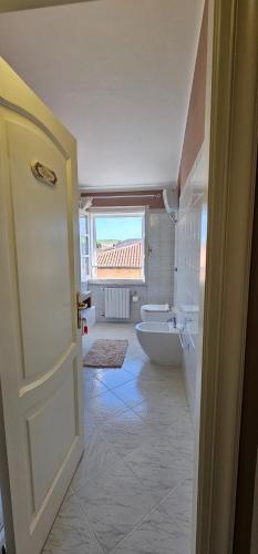 a bathroom with a toilet and a window and a door at Villa Teresa in Oschiri