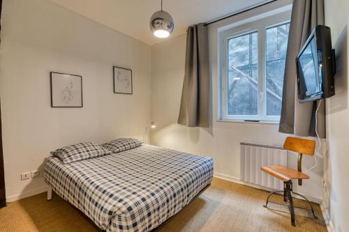 1 dormitorio con 1 cama, TV y ventana en Charmant F2 rue du Gros Horloge à Rouen! en Rouen