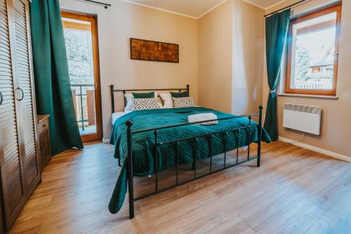 ザコパネにあるVisitZakopane - Ibiza Apartmentのベッドルーム1室(ベッド1台、緑の掛け布団付)