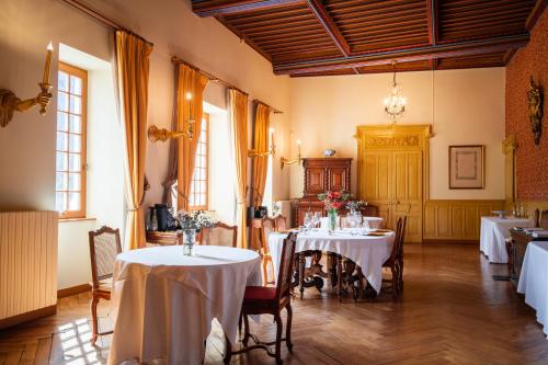 托朗格利耶爾的住宿－托朗格城堡酒店，用餐室配有带白色桌布的桌子