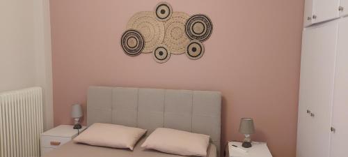 a bedroom with a bed and a clock on the wall at Hermes green in Artemida