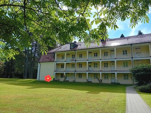 a large white building with a red flower on the lawn at Staufenhof in Bad Reichenhall