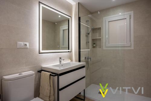 uma casa de banho com um lavatório, um WC e um espelho. em Vitvi Fuengirola - Premium Reyes em Fuengirola