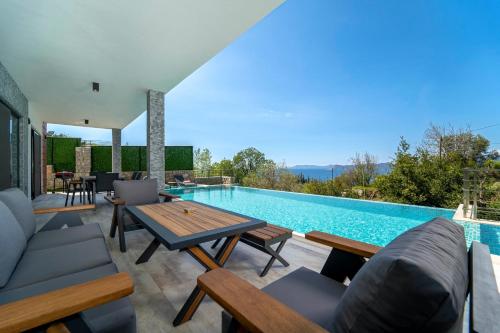 un patio con piscina, mesa y sillas en Villa Mariposa en Fethiye