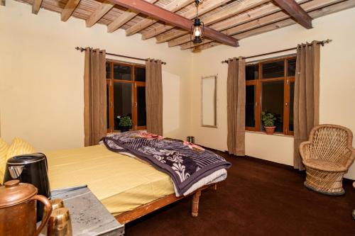 a bedroom with a bed in a room with windows at NotOnMap- Norbu Homestay Kaza in Kaza