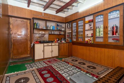 a large kitchen with wooden walls and cabinets and a counter at NotOnMap- Norbu Homestay Kaza in Kaza