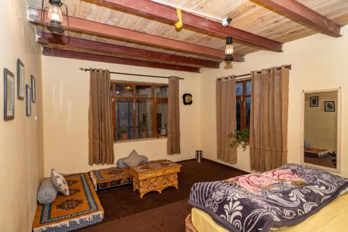 Sala de estar con cama y mesa en NotOnMap- Norbu Homestay Kaza en Kaza
