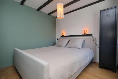 ノールトウェイクにあるHave a nice stay! - The Dutch nabij strand en boulevardの大きな白いベッドとシャンデリアのある寝室