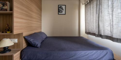 ein Schlafzimmer mit einem blauen Bett und einem Fenster in der Unterkunft Wandr Centauri in Bangalore