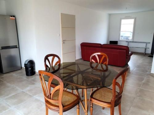 une salle à manger avec une table en verre et quatre chaises dans l'établissement MISTRAL ABBA a 500m de la plage, à Saint-Vincent-sur-Jard