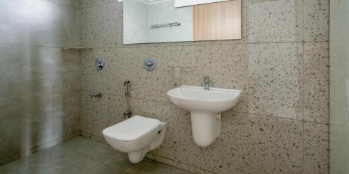 ein Badezimmer mit einem Waschbecken, einem WC und einem Spiegel in der Unterkunft Wandr Centauri in Bangalore