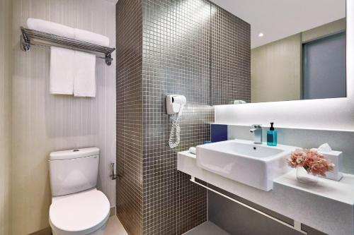 a bathroom with a white toilet and a sink at Vega Suites in Hong Kong