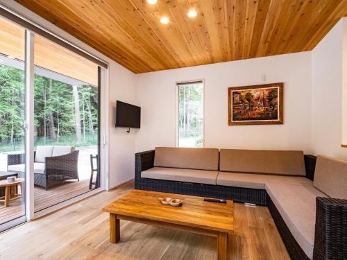 a living room with a couch and a table at 富士の星空 エフジェイフォレスト in Fujikawaguchiko