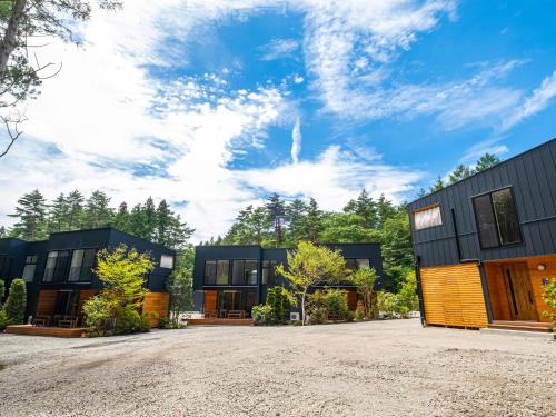 a group of houses with a gravel driveway at 富士の星空 エフジェイフォレスト in Fujikawaguchiko