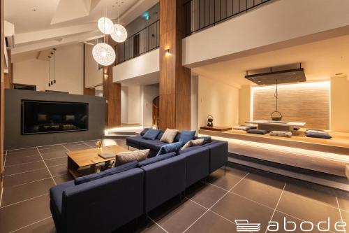 a living room with a blue couch and a tv at abode villa GORA 八代別邸 in Onsensō