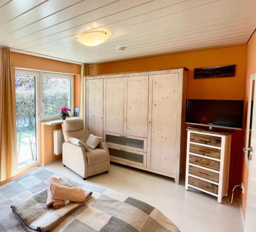 a living room with a bed and a tv and a chair at Ferienwohnung Singer in Bad Reichenhall