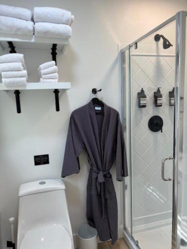 a bathroom with a toilet and a shower and towels at Cracker Cow Cottages - Cottage A in Fort Myers