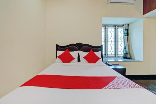 ein Schlafzimmer mit einem großen Bett mit roten Kissen in der Unterkunft OYO Blooms Inn in Bangalore