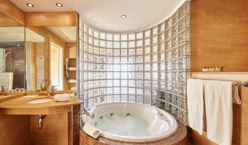 a bathroom with a tub and a sink at Hotel Samba in Lloret de Mar